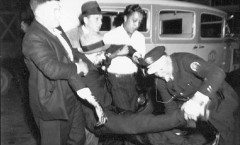 Police carry a bloodied protester away from the Flour City Ornamental Iron Company in September, 1935 after a labor protest turned violent.